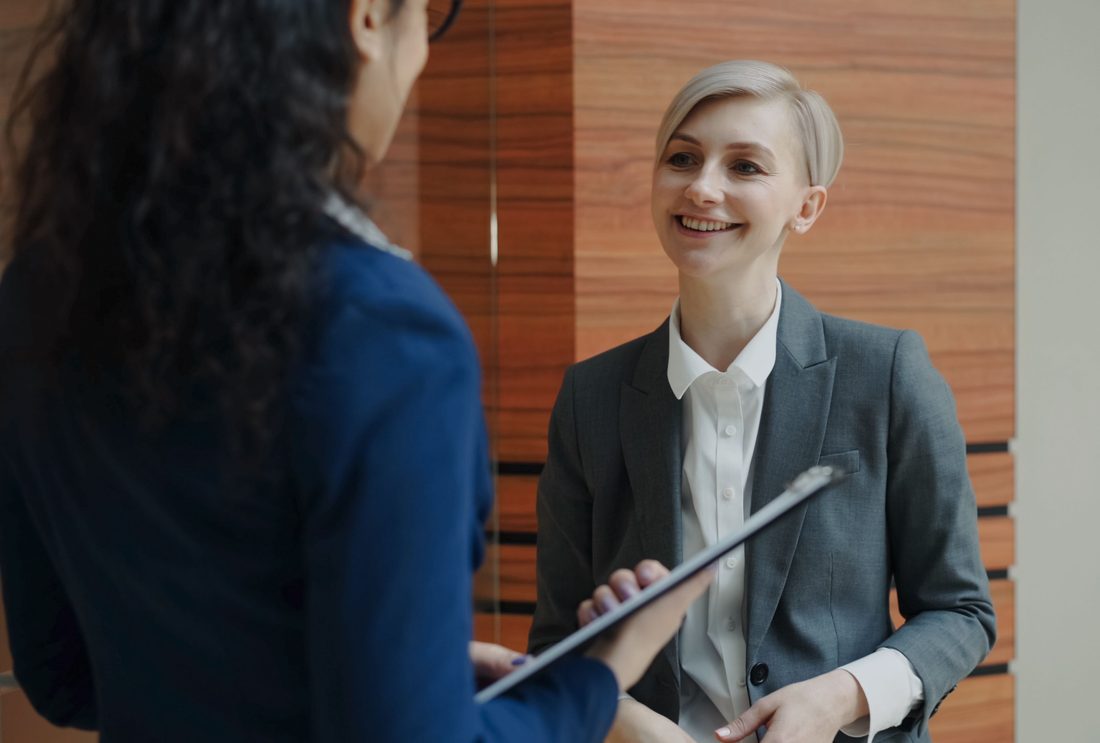 An HR consultant discussing documentation with a client in a modern office